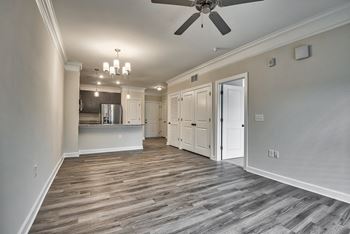 A spacious room with a ceiling fan and wooden flooring.